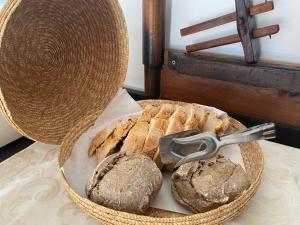 a basket with bread and a pair of tongs on a table at Vinha da Quinta in Sintra