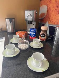a counter with four cups and saucers on it at Gemütliche Wohnung/ cozy apartment Niklasdorf in Niklasdorf