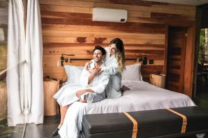 a man and woman sitting on a bed at Ort Hotel in Campos do Jordão