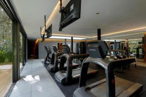 a gym with a row of treadmills and machines at Ort Hotel in Campos do Jordão