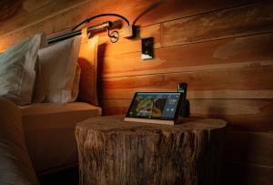 a laptop sitting on a tree stump next to a bed at Ort Hotel in Campos do Jordão