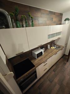 een keuken met witte kasten en een magnetron bij VIP lounge - self check in in Osijek