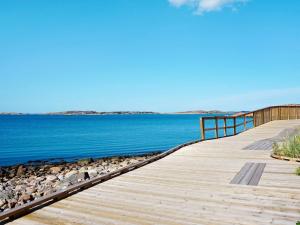 un paseo marítimo de madera que conduce al agua en una playa en Holiday home LYSEKIL IX, en Lysekil