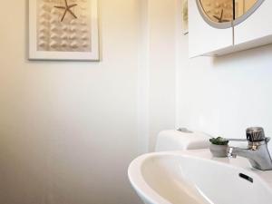 Baño blanco con lavabo y espejo en Holiday home LYSEKIL IX, en Lysekil