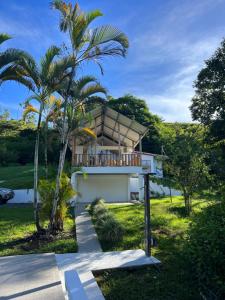 uma casa com uma varanda com uma palmeira em Finca Mango - 40 acre paradise 