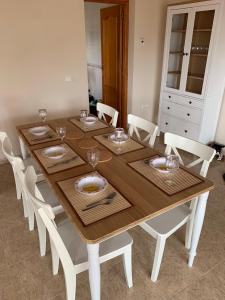 mesa de madera con sillas blancas y comedor en Casa Doble Sueno, en Orba