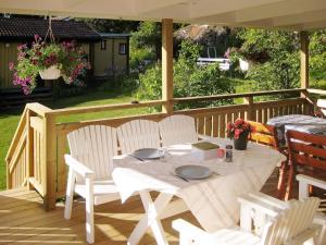 uma mesa branca e cadeiras num deque de madeira em Holiday home MALMKÖPING II em Malmköping