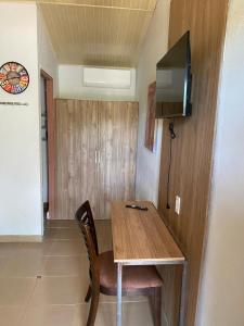 una mesa de madera y una silla en una habitación con TV en Casa Pueblo Ocú en El Hatillo