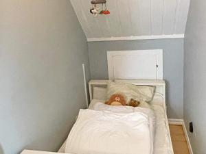 a stuffed teddy bear laying in a crib at Holiday home SÖLVESBORG V in Sölvesborg