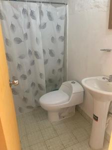 a bathroom with a toilet and a sink at Casa Pueblo Ocú in El Hatillo