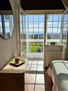 een slaapkamer met een bed en een groot raam bij Casa en Cambeo in Ourense