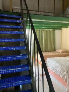 a staircase with blue steps in a room with a bed at Casa Pueblo Ocú in El Hatillo