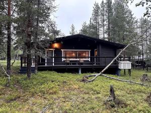a black cabin in the middle of a forest at Saajopolku 4 in Saariselka
