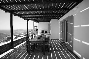 a wooden deck with a table and chairs on it at VILLA AMBROSIA in Khálara