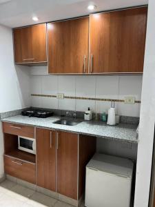 a small kitchen with wooden cabinets and a sink at Cálido dpto en pleno centro in Corrientes