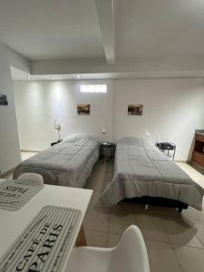a room with two beds and a table at Cálido dpto en pleno centro in Corrientes