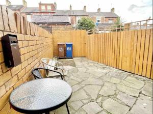 a patio with a table and chairs and a fence at Summer Lane House-3 Bedrooms-Close to M1-Longer Stay-Free Parking in Barnsley