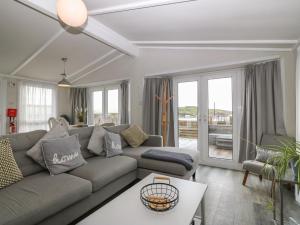 a living room with a couch and a table at Caban Tywod in Pwllheli