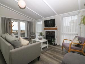 a living room with a couch and a fireplace at Caban Tywod in Pwllheli