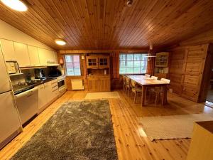a kitchen with a table and a wooden ceiling at Saajopolku 4 in Saariselka