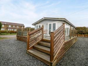 a home with a large deck with a house at Caban Tywod in Pwllheli
