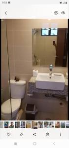 a bathroom with a white toilet and a sink at Grand Canal Penthouse! in Manila