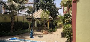 einen Innenhof mit Palmen und einem Wasserschlauch in der Unterkunft Villa L'Oasis in Ouagadougou
