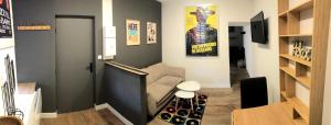 un pasillo con una habitación con sofá y póster de cine en Meublés déco Fab - Plancha en Luxeuil-les-Bains