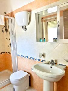 a bathroom with a sink and a toilet and a mirror at Apartment Difesa Pizzo in Pizzo