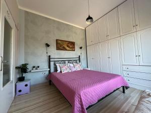 a bedroom with a bed with a pink bedspread at Vivian Philoxenia in Néa Sampsoús