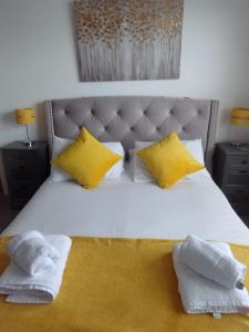 een slaapkamer met een bed met gele en witte kussens bij Beautiful Home in the centre of Newquay! in Newquay