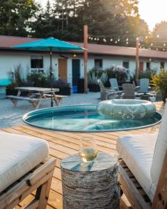 um copo de vinho sentado numa mesa ao lado de uma piscina em Penny's Motel em Thornbury