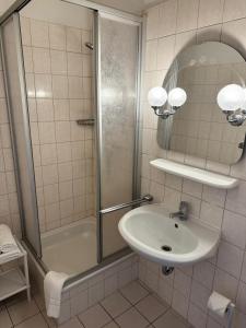 a bathroom with a sink and a shower at Hotel zur Eiche in Meerane