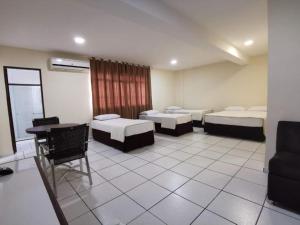 a room with three beds and a table and a desk at Smart Cataratas Hotel in Foz do Iguaçu