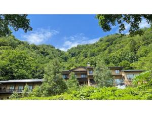 an apartment building in the middle of a mountain at Nakanoyu Onsen Ryokan - Vacation STAY 07500v in Matsumoto