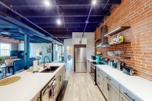 a large kitchen with a brick wall at Broadway Loft in Saint Louis
