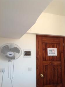 um quarto com uma ventoinha e uma porta com um sinal para não fumadores em EasyRoom em St. Paul's Bay