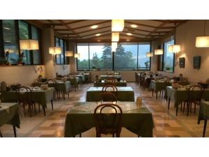 ein Esszimmer mit grünen Tischen, Stühlen und Fenstern in der Unterkunft Nakanoyu Onsen Ryokan - Vacation STAY 06687v in Matsumoto
