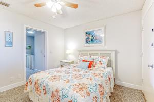 een slaapkamer met een bed en een plafondventilator bij Recently updated resort condo with 2 pools, 2 balconies, ocean views, BBQ, & W/D in St. Augustine +31 foto's