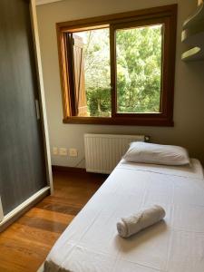 a bed in a room with a large window at Apartamento Quinta da Serra - Canela in Canela