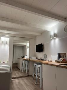 una cocina con armarios blancos y taburetes de bar en Visavi' Luxury Room, en Torre a Mare