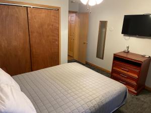 um quarto com uma cama, uma cómoda e uma televisão em Travelodge South Lincoln em Lincoln