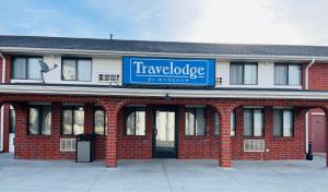 a large brick building with a blue sign on it at Travelodge South Lincoln in Lincoln
