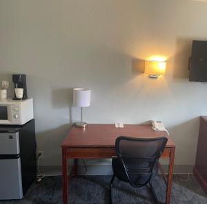 a desk with a lamp and a chair in a room at Travelodge South Lincoln in Lincoln