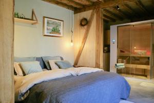 een slaapkamer met een groot bed in een kamer bij Boerderaaj in Bilzen