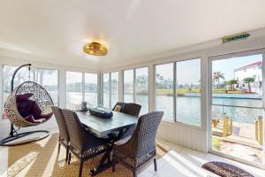 een eetkamer met een tafel, stoelen en ramen bij Little Pine Island Retreat in Hernando Beach