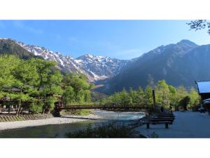 a bridge over a river with mountains in the background at Nakanoyu Onsen Ryokan - Vacation STAY 06670v in Matsumoto