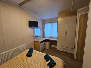 1 dormitorio con cama, escritorio y ventana en Rockley Park, The Poplars, en Lytchett Minster