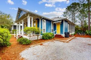 a blue and yellow house with a porch at Grove By The Sea: Passin' Thru in Santa Rosa Beach