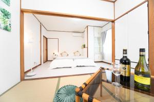 にあるKomono Garden Resort - Vacation STAY 06798vのベッド、ガラステーブル(ワインボトル付)が備わる客室です。